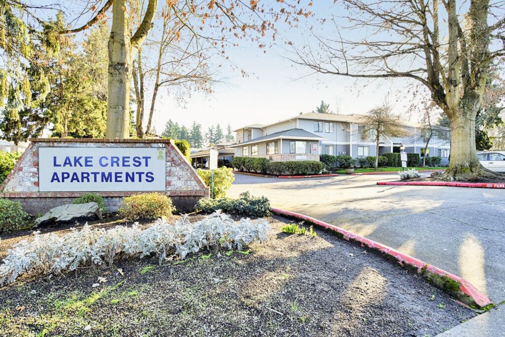 Parking lot entrance with monument sign for Lake Crest Apartments